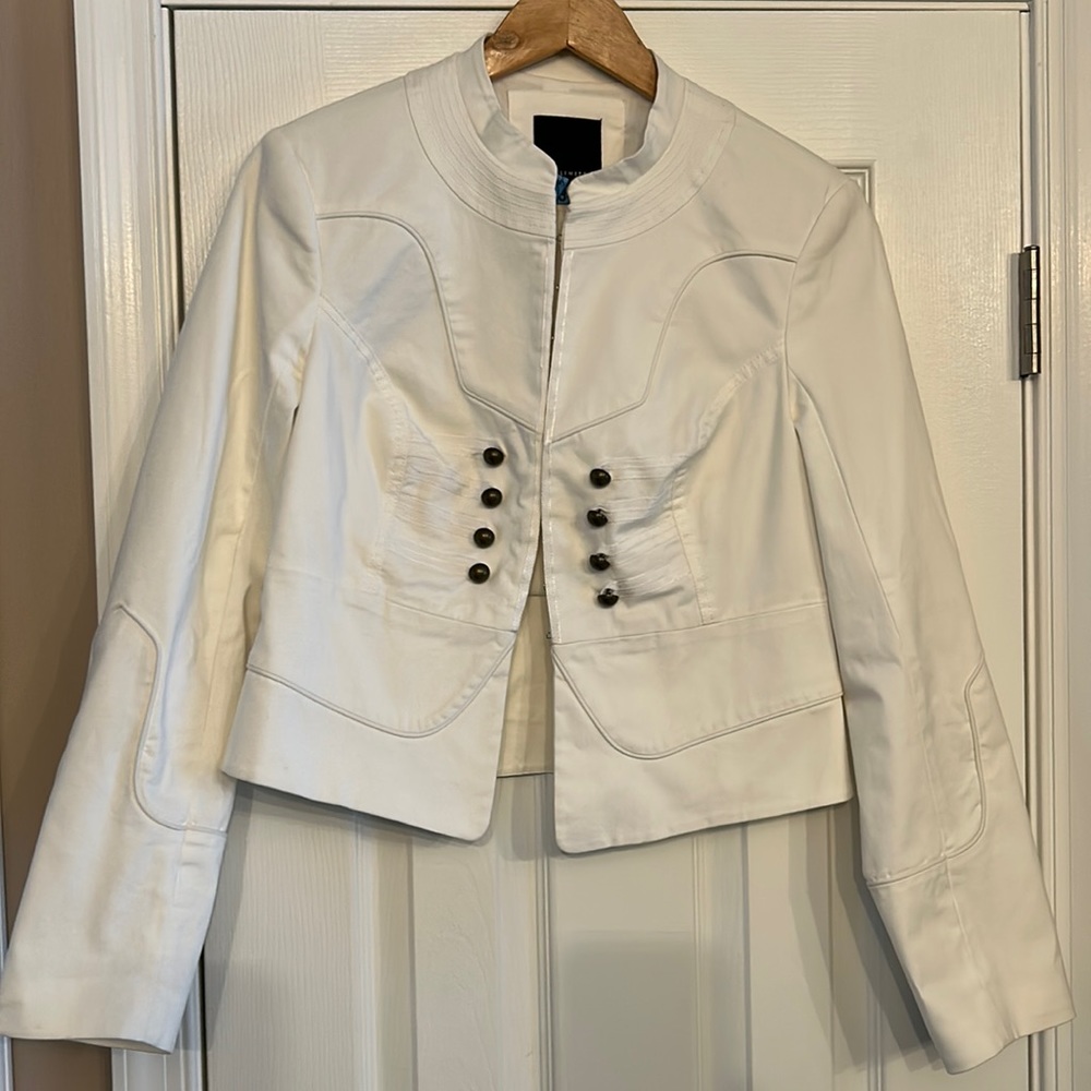 White cropped jacket with faux buttons in front and hook and eye closures.